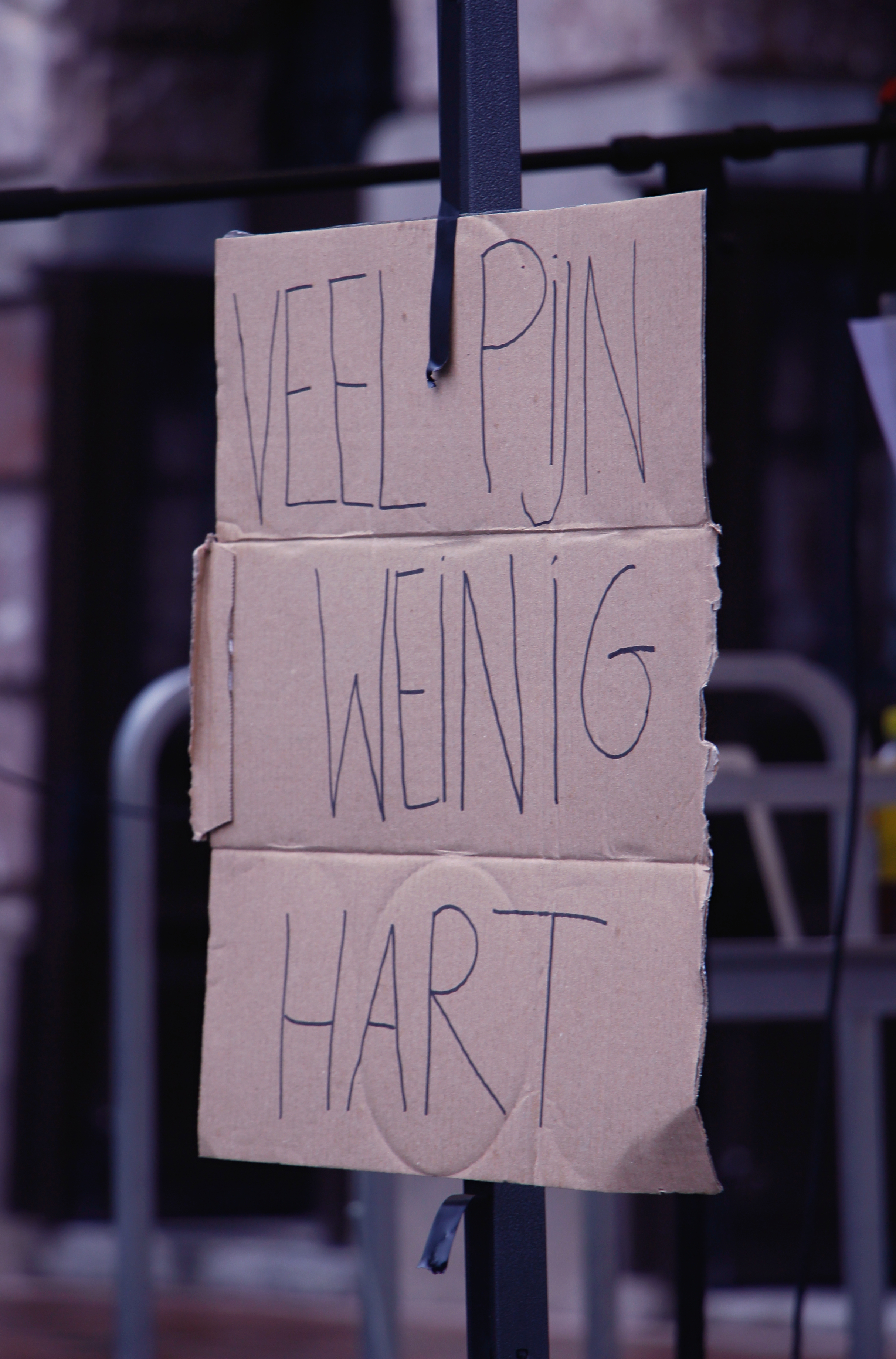 Kartonnen bord met de slogan "Veel pijn, weinig hart"