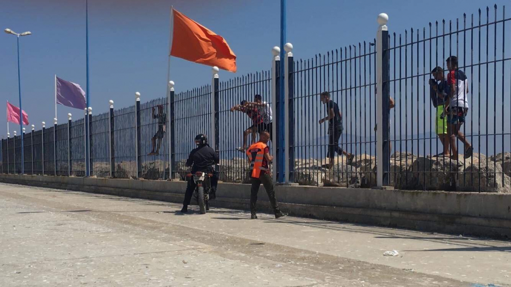 Jongeren proberen het hek met de Spaanse grens over te steken